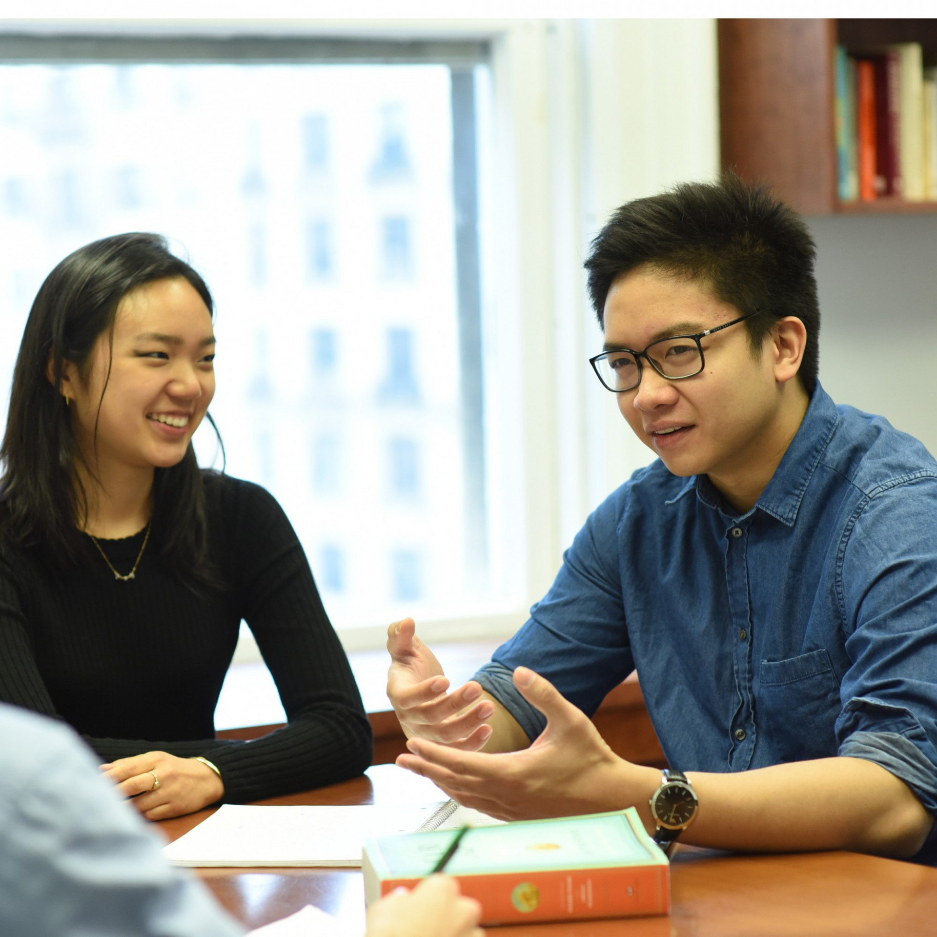 Dual BA students talking at a table